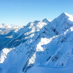 Scenic view of snowcapped mountains against clear blue sky