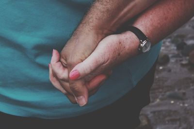 Cropped image of couple holding hands outdoors