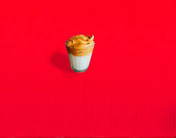 Glass of ice cream against red background