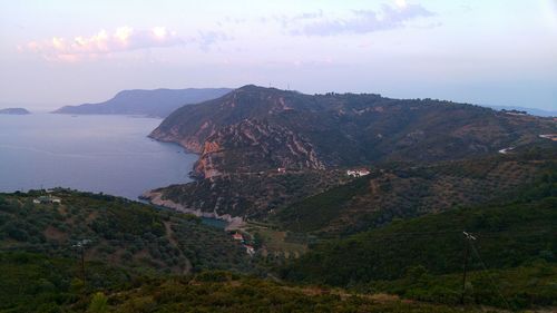 Scenic view of sea by mountains against sky