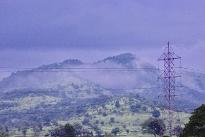 Electricity pylon on mountain against sky