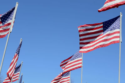 Low angle view of flag flags against clear blue sky