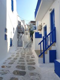 Houses and stone street amidst white buildings in city in sunshine 