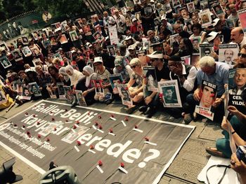 High angle view of crowd on city street with posters during mourning