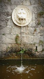 Sunlight falling on fountain against wall