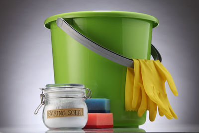 Close-up of yellow jar on table against wall