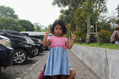 Portrait of young woman standing on road