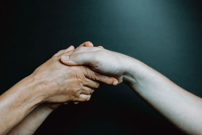 Close-up of woman hand over black background