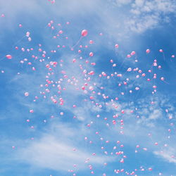 Low angle view of balloons flying against sky