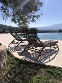 View of empty chairs on land against sky