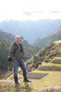 Full length of mid adult man standing against mountains