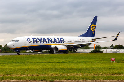 Airplane on airport runway against sky