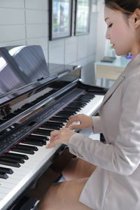 Midsection of woman playing piano