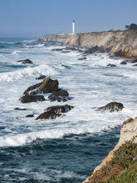 Rock formation on beach against sky