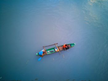 High angle view of fishermen in boat floating on sea