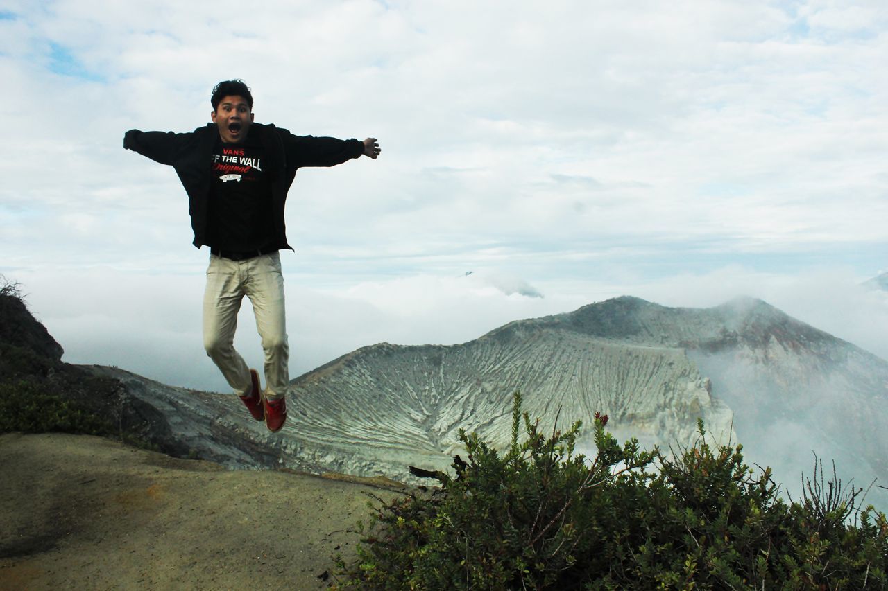 lifestyles, leisure activity, young adult, full length, mountain, sky, standing, casual clothing, young men, person, front view, tranquility, tranquil scene, nature, hiking, cloud - sky, men