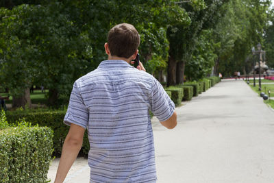 Rear view of man using mobile phone