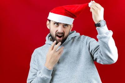 Portrait of man wearing hat against red background