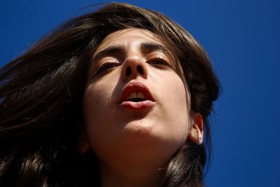 Close-up portrait of teenage girl against blue sky