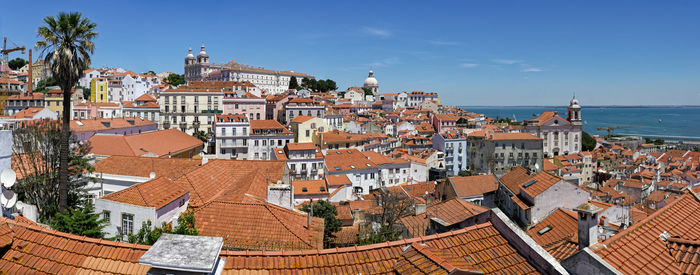 High angle view of townscape by sea against sky