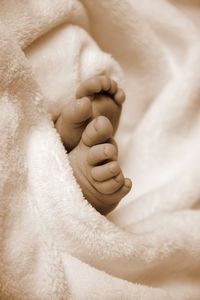 Close-up of baby hand on bed