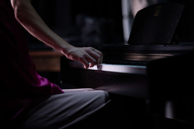 Midsection of man playing piano