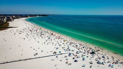 High angle view of people on beach against blue sky