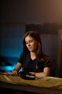 Portrait of young woman sitting on table