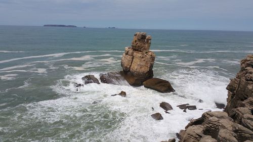 Rocks on sea shore against sky