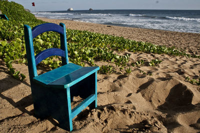 Deck chairs on beach against sea