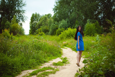 Young woman walking on dirt road in forest