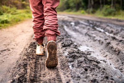 Low section of child standing on road