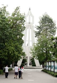 People walking by built structure against sky