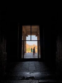 Silhouette people walking in corridor of building