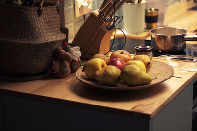 Fruits and nuts on a plate, apples, pears in the kitchen