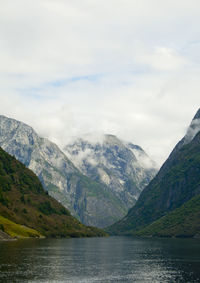 Scenic view of lake by mountains against sky