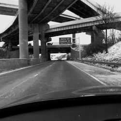 Road by bridge against sky