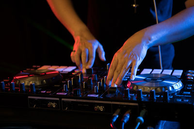 Low angle view of hands at music concert at night