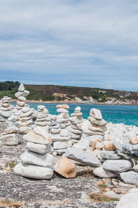 Stack of rocks in sea against sky