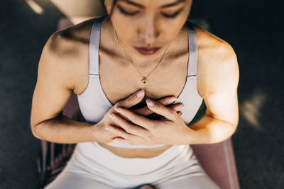 High angle view of woman exercising with hands on chest