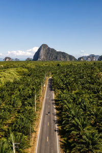 High angle view of road leading towards mountains against clear sky