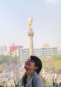 Woman wearing sunglasses looking away against sky