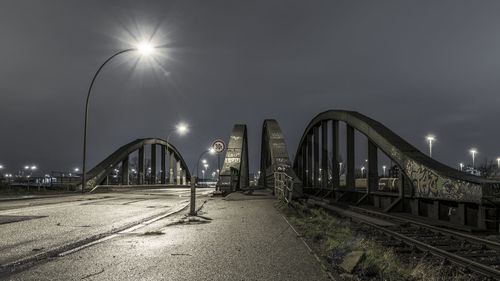 Illuminated bridge against sky at night