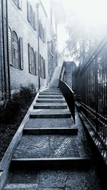 Staircase amidst buildings in city during winter