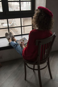 Rear view of couple sitting on chair at home