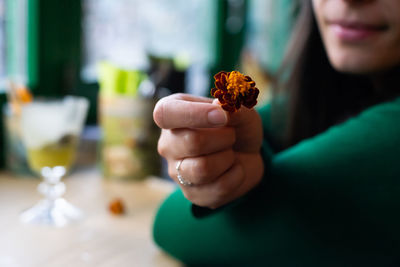 Midsection of woman holding flower at table