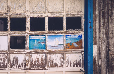 Old paintings on window of wooden wall