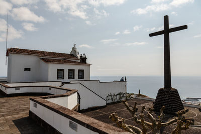 Traditional building by sea against sky