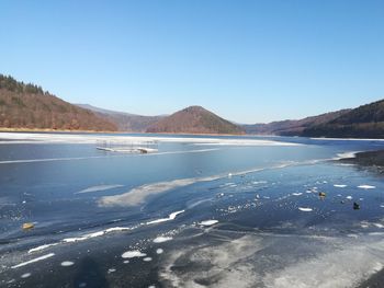 Scenic view of lake against clear blue sky