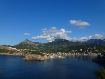 Scenic view of sea and mountains against blue sky porto soller, majorca